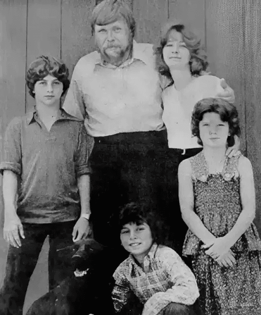 Retrato em preto e branco de Ronald DeFeo Sr., sua esposa e cinco filhos com um cachorro, antes da tragédia em Amityville.