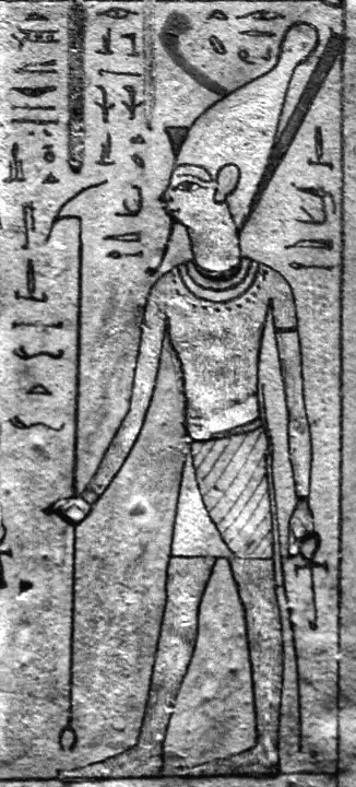 Baixo-relevo egípcio de a divindade Atum segurando o cetro Was e a chave Ankh. Hieróglifos cercam a figura real em uma representação clássica de poder e vida eterna.