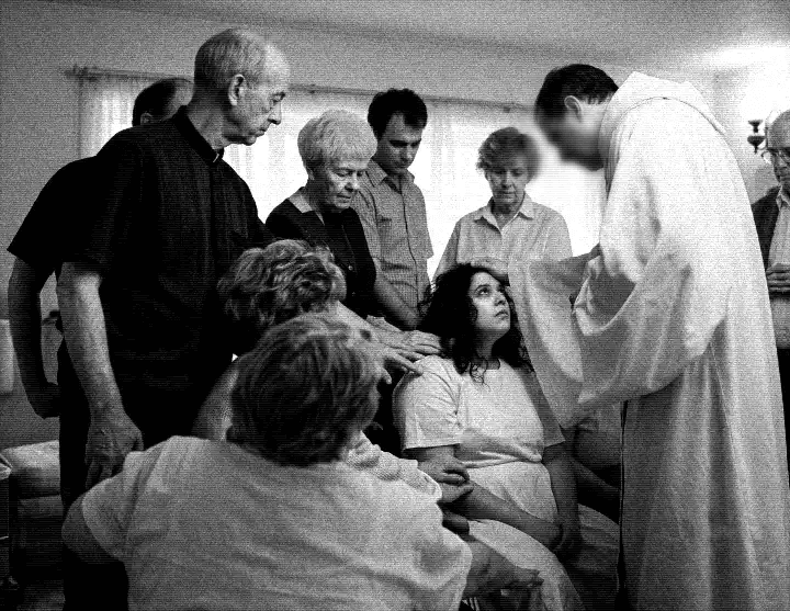 Cena granulada em preto e branco de um suposto exorcismo. Um grupo de pessoas impõe as mãos sobre uma mulher sentada, enquanto um padre em vestes claras conduz o ritual religioso.