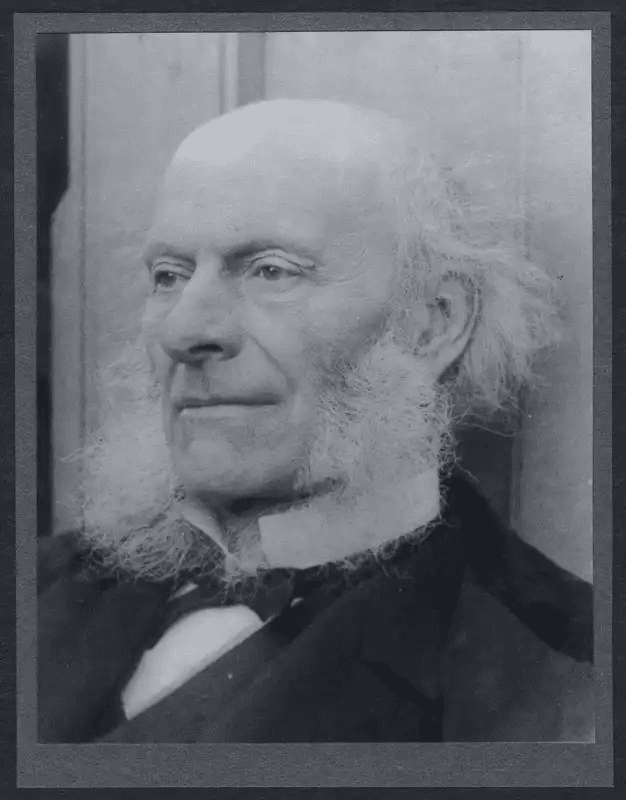 Retrato antigo em preto e branco de Francis Cranmer Penrose idoso e calvo, com longas costeletas brancas e expressão séria. Estilo clássico de um estudioso do século XIX.