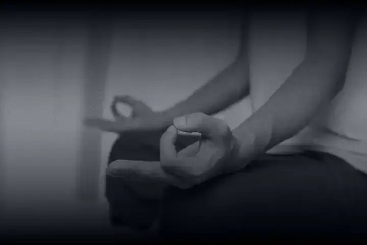 Meditação: Close-up de mãos em mudra de meditação sob luz suave e difusa. Imagem em preto e branco que transmite serenidade, foco interno e conexão com o invisível.